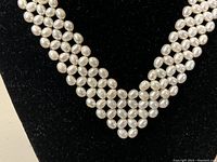 Close-up of multi-strand braided white freshwater pearl necklace showing bead detail