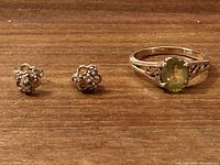 Ring and earrings displayed on wood surface from front view