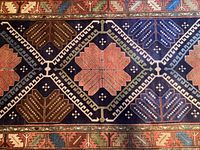 Close-up of central medallion and surrounding geometric motifs on navy field