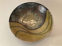 Top view of the John Charnetski Raku pottery bowl showing glazed interior with wavy black lines and textured surface.