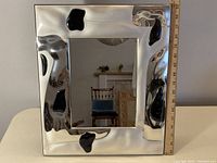 Front view of the large silver framed mirror with a ruler showing height approximately 23 inches.
