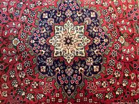 Close-up of central cream and navy floral medallion on red field