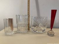 Four glass items arranged in a row showing size, shape and color differences
