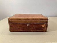 Front and top external view of a vintage Florentine leather jewelry box showing overall shape and some wear to leather