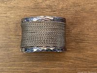 Top view showing the cuff's wide woven mesh silver center and hammered silver edges.