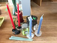 Full view of various candles, candleholders, and figurines arranged on table showing assortment and sizes