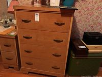 Front view of mid-century modern wood dresser with four drawers and metal pulls in a light wood finish.