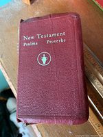 Closeup photo of a red textured cover book titled New Testament Psalms Proverbs.
