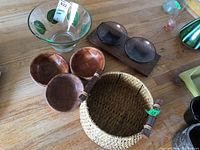 Wide view showing glass bowls, wood platter with attached bowls, plastic salad bowls, and basket