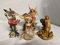 Display of all four fairy figurines together on white background