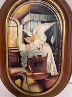 Full view of the oval guardian angel collector plate mounted in a wooden frame with a cradle scene.