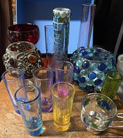 Full view of all mosaic vases and bowls with colored shot glasses in front