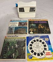 White GAF View-Master viewer with four reels and their packaging, showing titles and condition