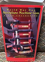 Box front showing four machine gun models mounted on a wooden display rack labeled 'World War One Aeroplane Machine Gun 4 Gun Collection'. Guns labeled Lewis Gun, Vickers, Spandau, and Parabellum.