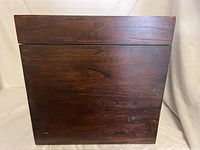Front and side view of cube wooden chest showing dark stained wood with scratches and imperfections.