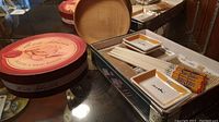 Sushi service set, brie baker box, and wooden nut bowl displayed on glass table