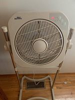 Front view of the Air Innovation fan showing the grille, control buttons and part of the stand.