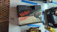 Weller soldering gun kit in black plastic case with original box branding showing the soldering gun and accessory tips.