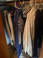 Hanging women's clothing items including jackets, tops, sweaters in assorted colors and prints.