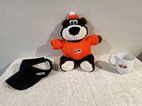 Full lot image showing A&W Rooty Bear plush in orange sweater, black visor, and white mug against a neutral backdrop.