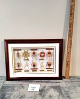 Front view of the framed nautical rope knot art piece next to a yardstick for size reference.