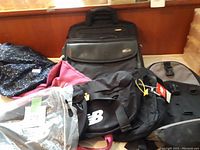 Photo showing various laptop bags and backpacks stacked together with visible brand logos.