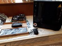 Lot laid out on mattress including computer case to the right, motherboard with CPU and RAM on box, and graphics card on a box below motherboard.