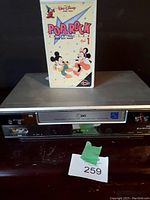 LG VHS player with Disney Pop & Rock VHS tape on top, photo taken to show player front and tape included.
