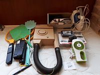 Photo showing hair dryer, two bug killer rackets, handheld fan, two irons, backup camera