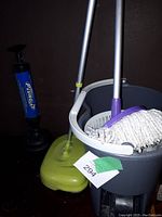 Photo showing mop with bucket, blue heavy duty pump plunger, and green dust picker