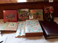 Front view of eleven photo albums with varied Disney and floral covers arranged upright and laid flat.