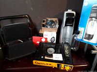 Wide view showing all items in the lot including SodaStream, gas stove, and grill