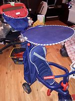 Side and front angle of blue SmarTrike toddler stroller showing sunshade canopy, molded seat, and handlebar