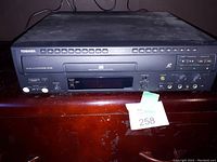 Front view of Toshiba LD/CD player showing disc slot, control buttons, and front panel microphone inputs and knobs.