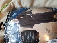 Packaged set showing a black blouse or jacket with product details on packaging.