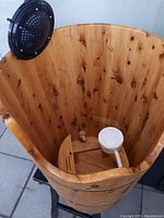 Inside view showing thick wooden construction, built-in removable footrest slats, and plastic drainage pipe at bottom center.