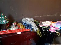 Photo showing Coca-Cola Christmas tree decoration, tinsel garlands, and some gift bags.