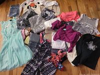 Wide view of assorted children clothing items laid out on floor showing whole lot contents