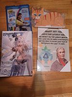 Photo showing the anime figurine model kit box, orange tabby cat sculpture, inspirational art poster with Native American elder, and a Crayola kids' art set.