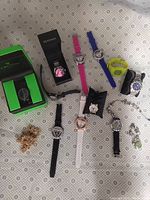Full lot view showing diverse wristwatches and bracelets arranged on patterned cloth