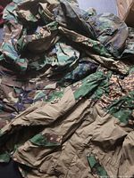 Photo showing multiple camouflage jackets in various patterns and colors laid out together