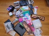 Shows the assortment of miscellaneous items including art supplies, small household gadgets, and personal care items spread on the floor.