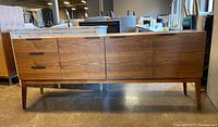 Full front view of walnut veneer buffet showing three drawers on the left and three cupboard doors on the right