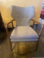 Front view showing chair profile, upholstery and wood finish