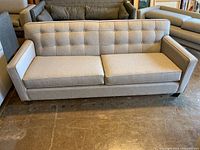 front view of sofa showing tufted back and seat cushions