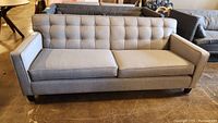 Front view showing full sofa with tufted back and seat cushions