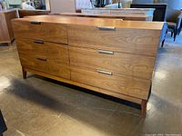 Angled front view showing six drawer dresser and tapered legs