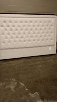 Full front view of beige tufted headboard