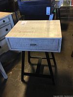 Front view of the wooden nightstand highlighting the drawer and top surface.