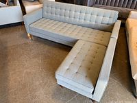Angled front view showing entire sectional with three-seat section on left and chaise on right.